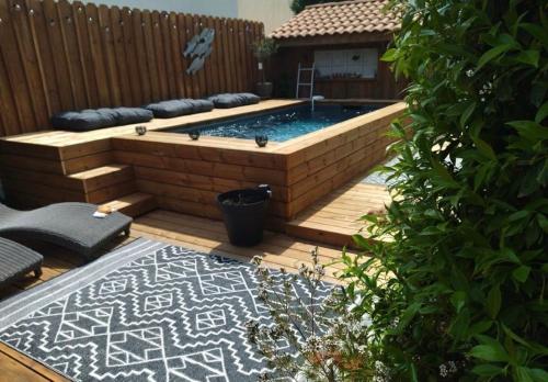 - une piscine dans un jardin avec une clôture en bois dans l'établissement Le logis de tine, à Arcachon