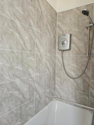 a bathroom with a shower with a white tub at Stylish modern Cottage, Kidderminster in Kidderminster