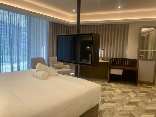 a hotel room with a bed and a flat screen tv at Coastlands Skye Hotel, Ridgeside, Umhlanga in Durban