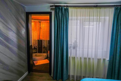 a bathroom with a tub and a shower with a window at Casa Andra in Baia de Fier