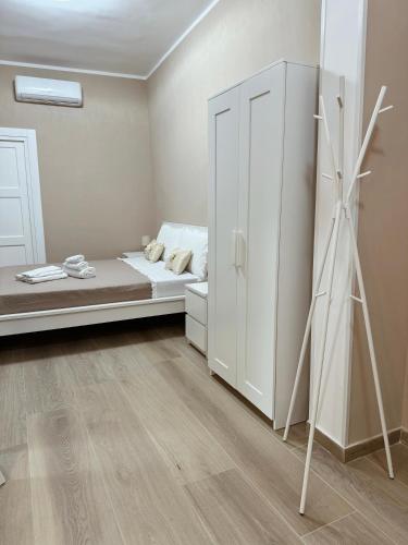 a bedroom with a bed and a white cabinet at Nonno Ciro B & B in Torre Annunziata