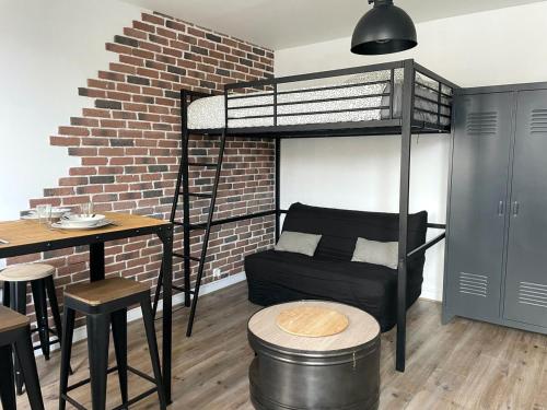 Cette chambre comprend une mezzanine avec un canapé et une table. dans l'établissement ღ Le Templier - Studio Centre Ville, à La Rochelle