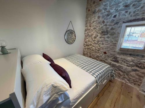 Ce lit se trouve dans une chambre dotée d'un mur en pierre. dans l'établissement Lovely One-Bedroom Apt- Picasso 4 -Stay In Antibes, à Antibes