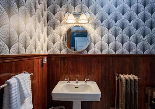 a bathroom with a sink and a mirror at Akrons Werner House Historic 4 Bedroom Luxury in Akron