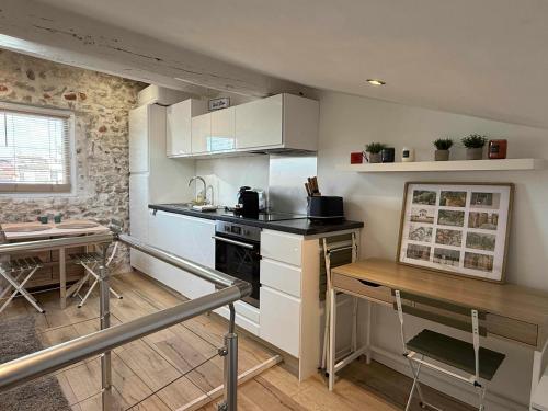 Il comprend une petite cuisine équipée d'une cuisinière et d'une table. dans l'établissement Lovely One-Bedroom Apt- Picasso 4 -Stay In Antibes, à Antibes