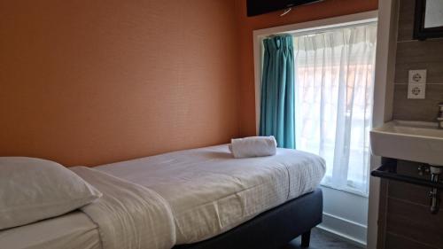 a bedroom with a bed and a window and a sink at Tourist Inn One Amsterdam in Amsterdam