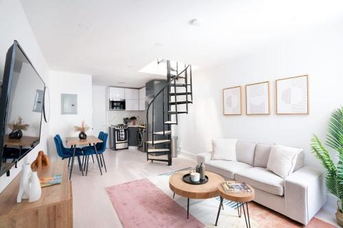 a living room with a white couch and a spiral staircase at 78-4A 2BR Duplex with a Balcony Prime UES in New York