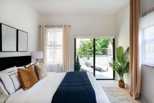 a white bedroom with a large bed and a patio at 78-4A 2BR Duplex with a Balcony Prime UES in New York