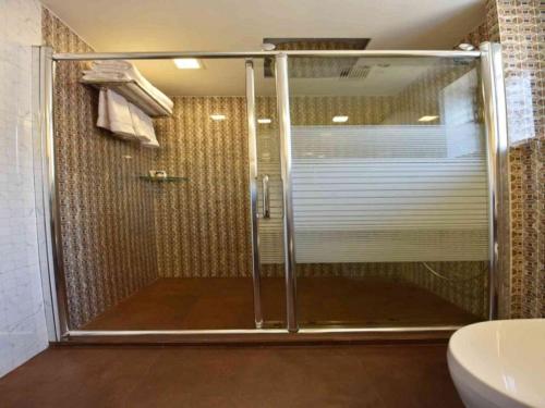 a shower with a glass door in a bathroom at Hotel Calangute Central in Calangute