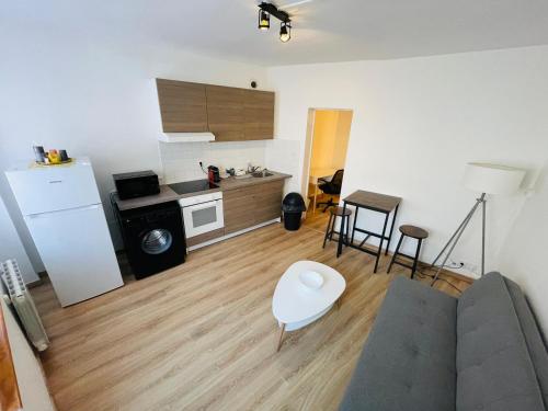un salon avec un canapé et une cuisine dans l'établissement Nid urbain à 2 pas de la gare - 383, à Rouen