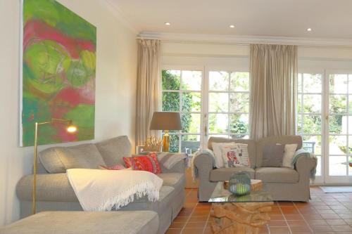 a living room with two couches and a painting at Haus Munkhoog in Munkmarsch