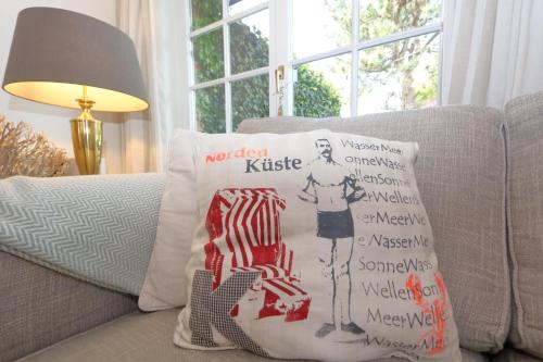 a pillow on a couch next to a lamp at Haus Munkhoog in Munkmarsch