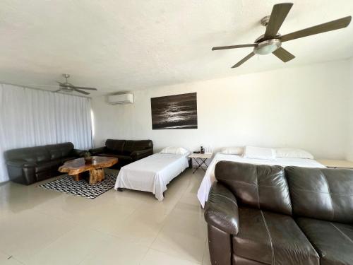 a living room with a couch and a ceiling fan at Estudio con WiFi, Netflix y Aire in Ixtapa