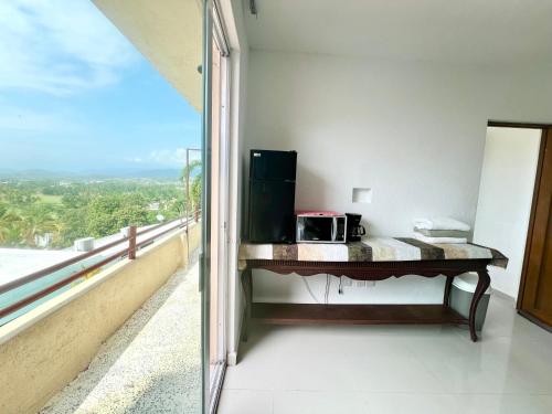 a room with a table with a microwave on a balcony at Estudio con WiFi, Netflix y Aire in Ixtapa
