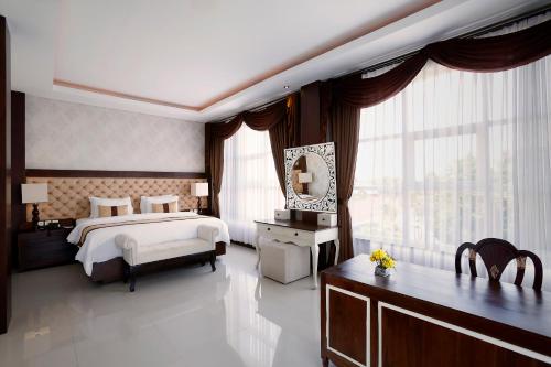 a large bedroom with a bed and a mirror at The Visala Boutique Suites Seminyak in Seminyak