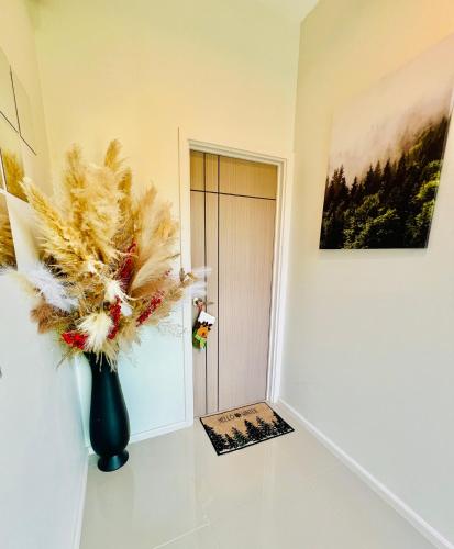 a vase with feathers in a room with a door at Relax Pool Villa Khaoyai - รีแล็กซ์พูลวิลล่าเขาใหญ่ in Ban Bung Toei