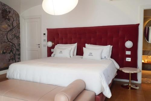 a bedroom with a large bed with a red headboard at Palazzo Martinelli in Sorrento