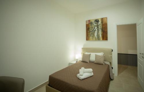 a bedroom with a bed with two towels on it at Umberto Home 303 in Catania