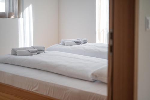 two beds sitting next to each other in a room at Speluca Brauerei & Genusshotel - Self-Check-in in Splügen