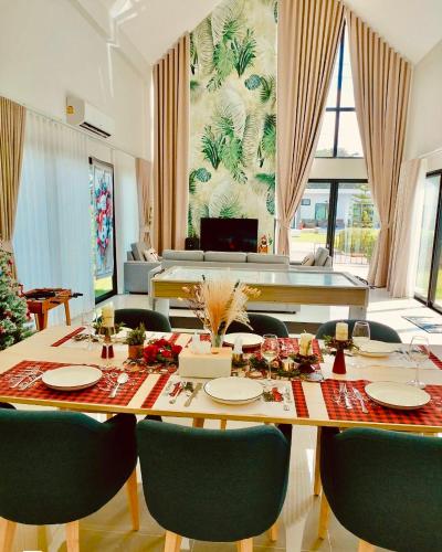 a dining room with a table and chairs at Relax Pool Villa Khaoyai - รีแล็กซ์พูลวิลล่าเขาใหญ่ in Ban Bung Toei