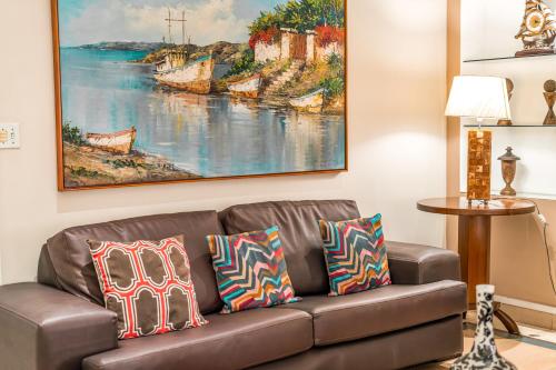 a couch in a living room with a painting on the wall at Hotel Nacional Inn Guarujá in Guarujá