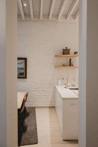 a white kitchen with a sink and a table at Blue Bird Residence in Antwerp