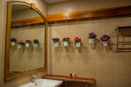 a bathroom with potted flowers on the wall at Seawave Guest House in Hua Hin
