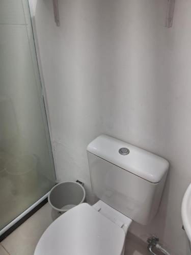 a bathroom with a white toilet and a sink at Pousada Ebenézer, Foguete in Cabo Frio