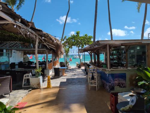 a restaurant on the beach with the ocean in the background at Dios es Fiel - Ali Hotel in Punta Cana