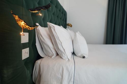 a bedroom with a bed with white pillows at Palazzo Martinelli in Sorrento