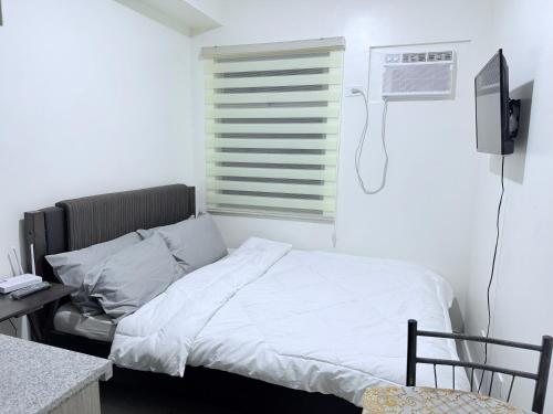 - une chambre avec un lit et une fenêtre climatisée dans l'établissement Urban Deca Towers Cubao, à Manille