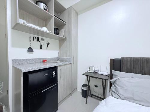 - une petite chambre avec un lavabo et un lit dans l'établissement Urban Deca Towers Cubao, à Manille