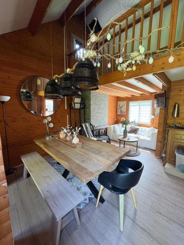 a living room with a wooden table and a couch at Chalet convivial avec vue sur la rivière - 62 m² in Authuille
