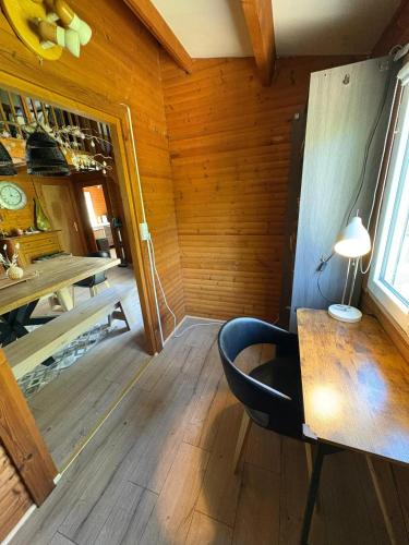 a room with a table and a chair in a room at Chalet convivial avec vue sur la rivière - 62 m² in Authuille