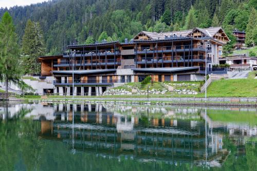 a large building next to a large body of water at Campiglio WOOD in Madonna di Campiglio