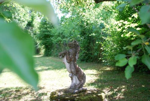 a statue of a bird sitting on a rock in a yard at Der Turm Leiben Apartments in Leiben