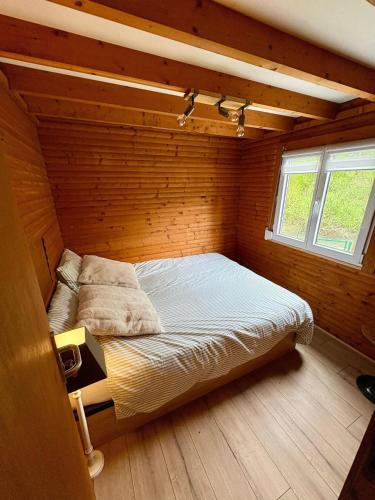 a bedroom with a bed in a wooden room at Chalet convivial avec vue sur la rivière - 62 m² in Authuille