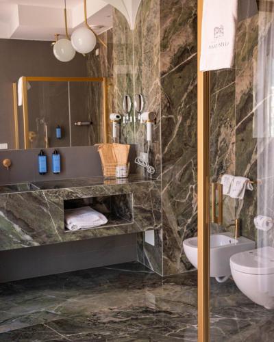 a bathroom with a sink and a toilet and a mirror at Palazzo Martinelli in Sorrento
