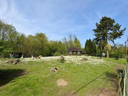 a field with a house on top of it at Chalet convivial avec vue sur la rivière - 62 m² in Authuille