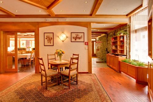 a dining room with a table and chairs and a dining room at Hotel Parnass in Zermatt