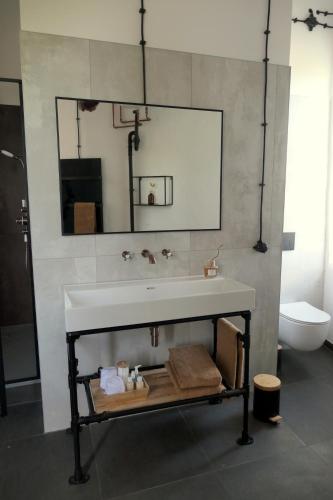 a bathroom with a white sink and a toilet at Watertoren Hengelo in Hengelo