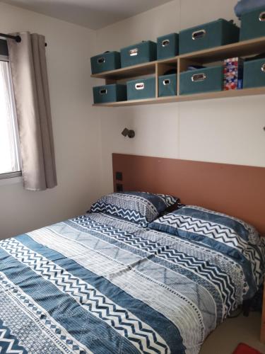 un lit dans une chambre avec des étagères vertes dans l'établissement Camping Agde Mobil home 4 places , climatisé, à Agde