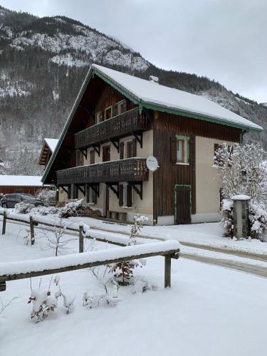 un bâtiment avec de la neige sur le sol devant lui dans l'établissement Apartment Alys, contemporary style apartment in mountain village, à Abondance