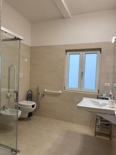 a bathroom with a toilet and a sink and a shower at La Dimora Degli Dei in Carovigno