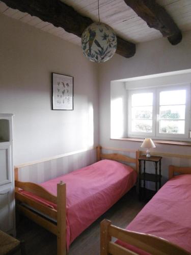 une chambre avec deux lits et deux fenêtres dans l'établissement La Bergerie - Manoir de Kerhir, à La Celle-sous-Gouzon