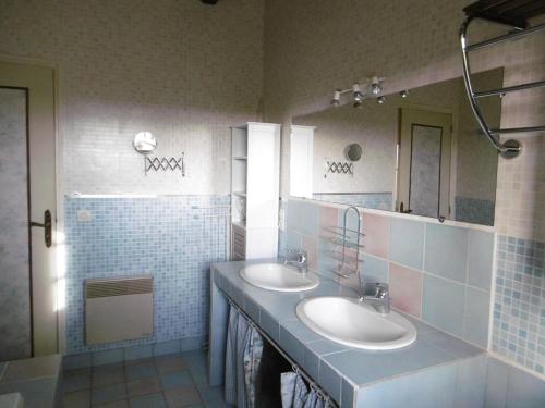 une salle de bain avec deux lavabos et un miroir dans l'établissement La Bergerie - Manoir de Kerhir, à La Celle-sous-Gouzon