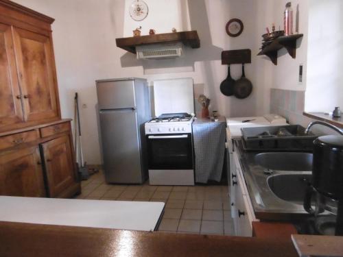 une cuisine avec une cuisinière et un réfrigérateur dans l'établissement La Bergerie - Manoir de Kerhir, à La Celle-sous-Gouzon