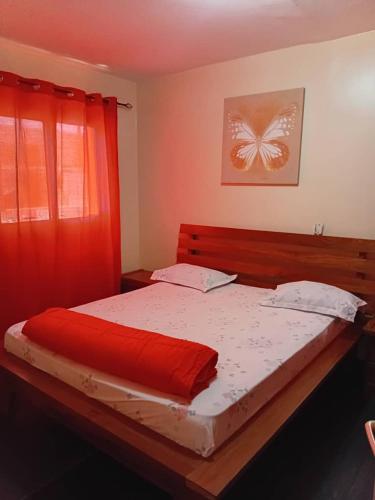 a bedroom with a large bed with a butterfly painting on the wall at Appartement Beau Séjour in Dakar