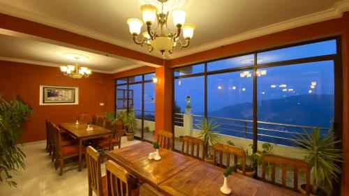 a dining room with a table and a large window at Hotel Nagarkot Inn in Nagarkot