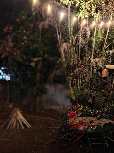 a table and chairs in a garden at night at AquaTerra Comfy stay Varkala beach in Varkala